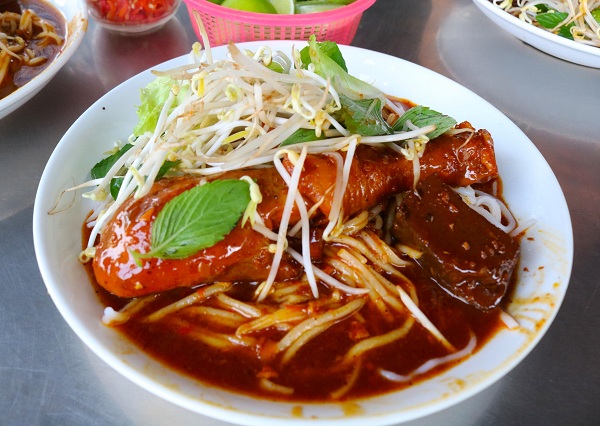 Silkworm cake and curried chicken are served with bean sprouts and salad