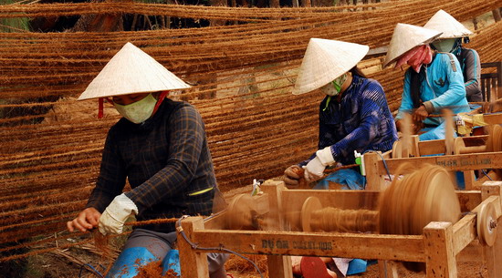 Women are weaving mats by using coconut fibers 