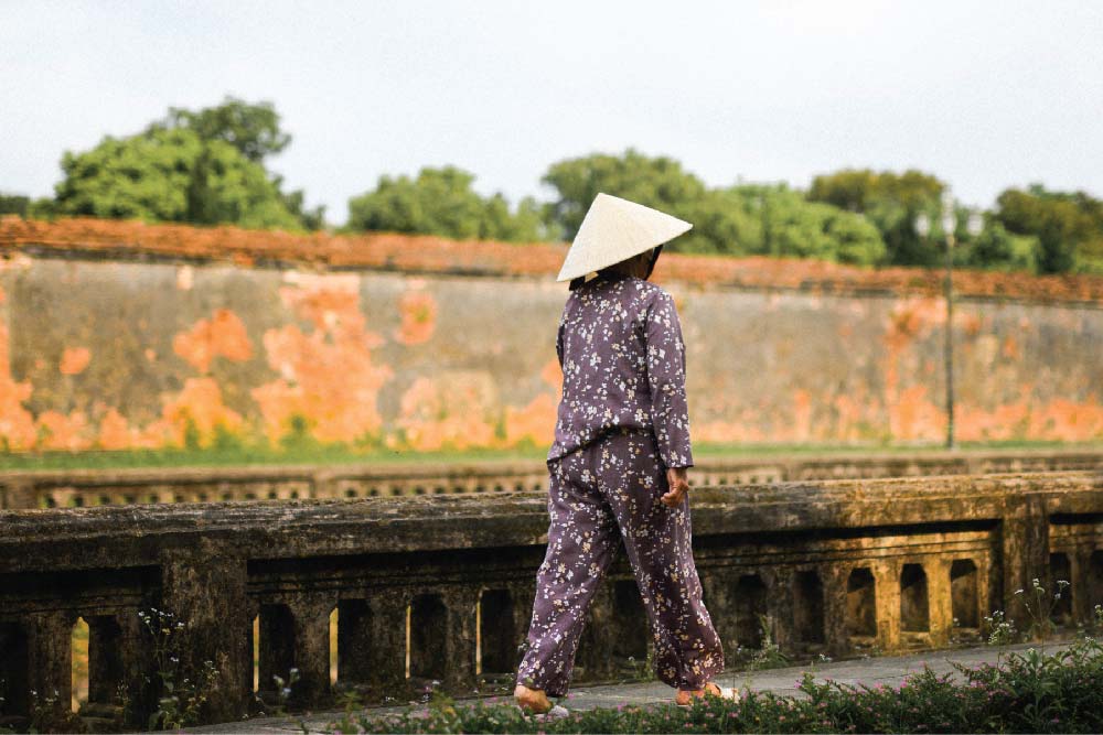 woman-wearing-non-la-walking-across-Vietnam-street